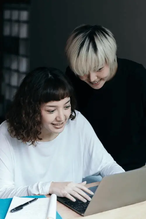 cheerful women browsing Teams while working on a project