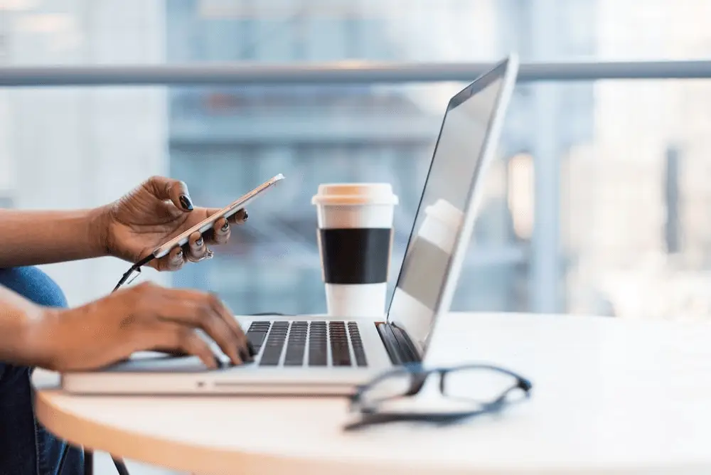 A person using their phone and laptop
