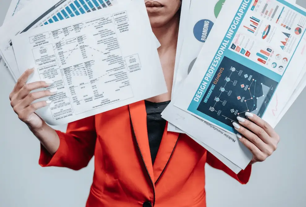 a woman holding loads of documents