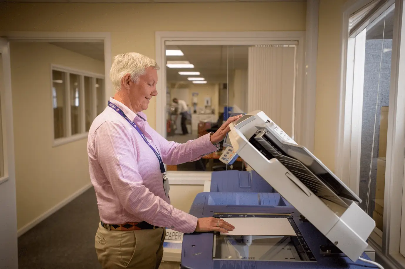 A person using an all-in-one-copier in the office